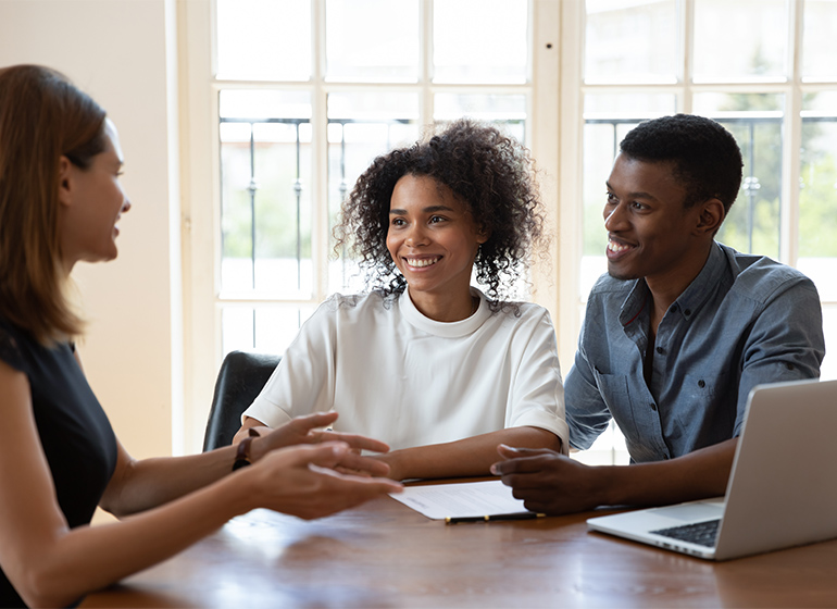 Smiling diverse clients meeting loan officer at office