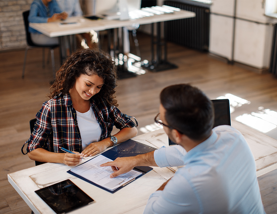 Young woman signing contract with manager